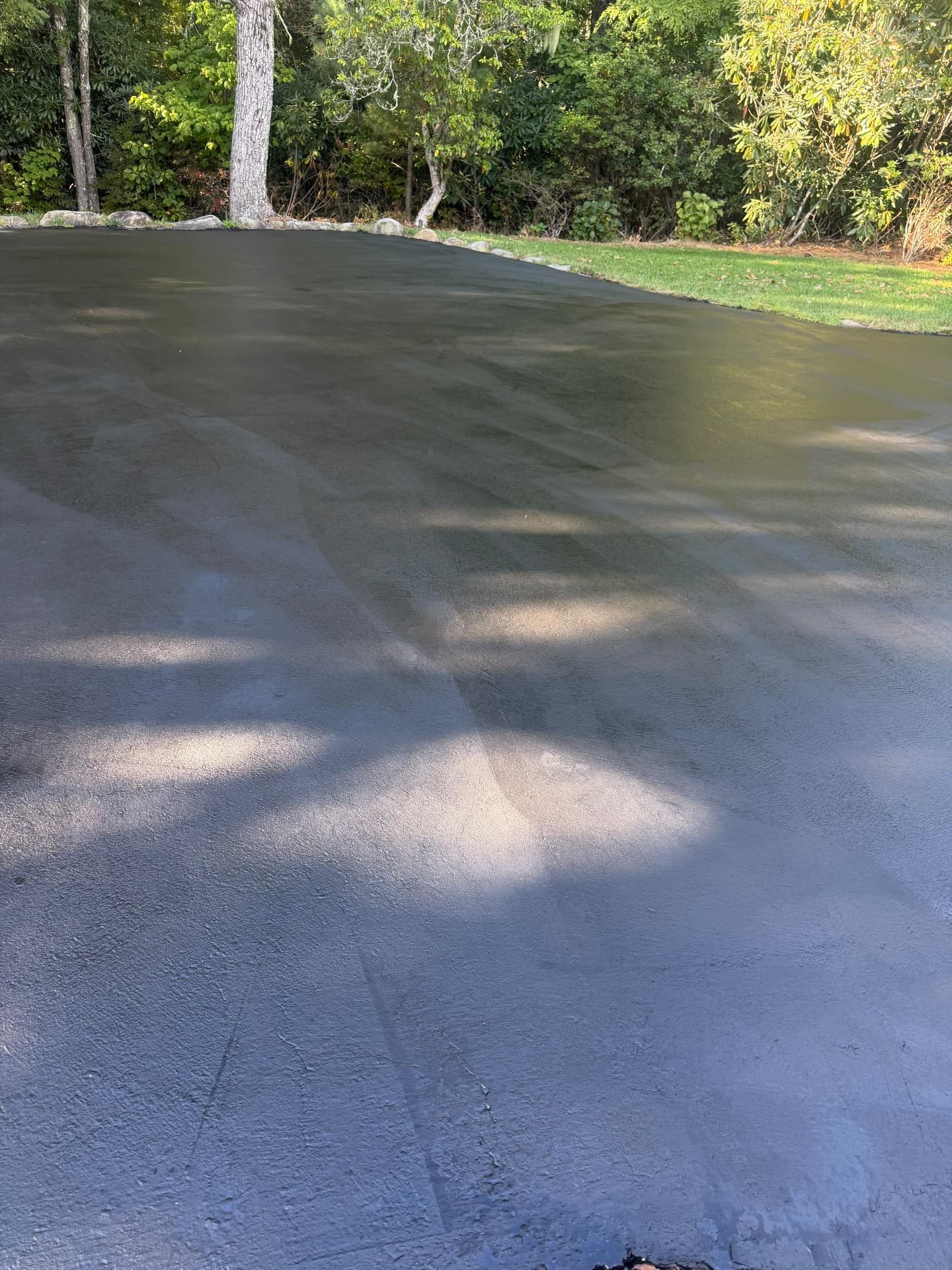 Freshly sealed asphalt driveway with a uniform matte black finish